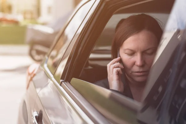 Empresária falando no celular dentro do carro da empresa — Fotografia de Stock