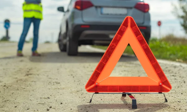 A jármű meghibásodása és figyelmeztető háromszög az úton — Stock Fotó