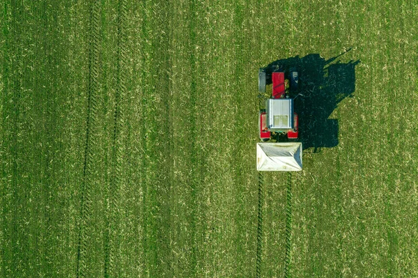 Agricultural tractor fertilizing wheat crop field with NPK — Stock Photo, Image