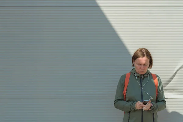 路上でテキストメッセージのためにスマートフォンを使用して女性ジョガー — ストック写真