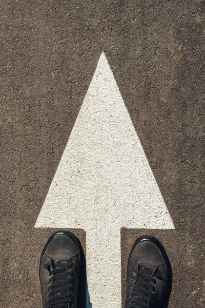Городской исследователь, человек в современной обуви, стоящий на асфальтированной дороге — стоковое фото