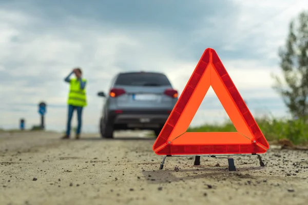 Rozbicie pojazdu i trójkąt ostrzegawczy na drodze — Zdjęcie stockowe