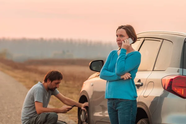 Pareja de reparación de neumáticos pinchados de coche en la carretera — Foto de Stock