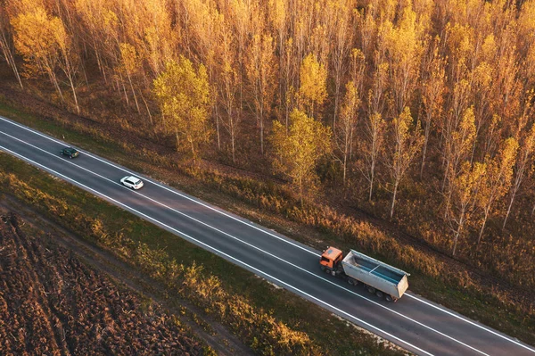 Aerial view of traffic on road through autumnal cottonwood fores — Stock Photo, Image