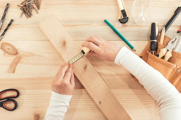 Blick von oben auf Tischlerhände, die am Schreibtisch arbeiten — Stockfoto