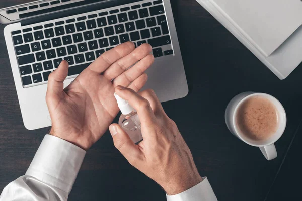 Adamı Ofis Masasında Çalışırken Dezenfektan Spreyi Kullanıyor — Stok fotoğraf