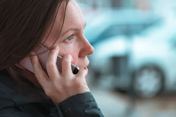 在现代城市周围的街道上使用手机进行室外交流的临时妇女 有选择地集中注意力 — 图库照片