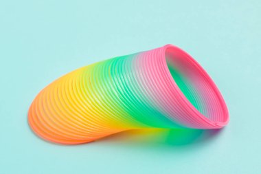 Mavi arka planda renkli sihirli plastik spiral yaylı oyuncak