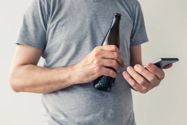 喝啤酒和使用智能手机 有选择地紧握着男性的手 — 图库照片