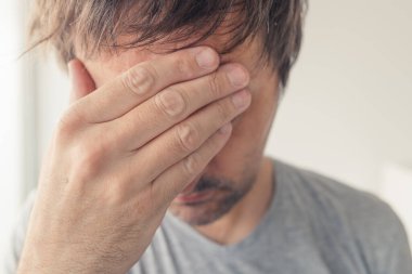 Baş ağrısı, viral enfeksiyon belirtileri olan bir adam seçici odak portresini kapatın.