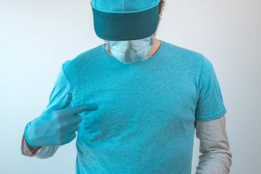 Koruyucu iş kıyafetleri giyen, mavi tişörtlü, mavi şapkalı ve göğsünü gösteren koruyucu eldivenli bir teslimatçı.