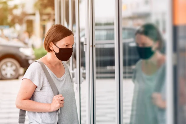 Vrouw Met Beschermend Gezichtsmasker Kijkend Naar Etalage Tijdens Coronavirus Covid — Stockfoto