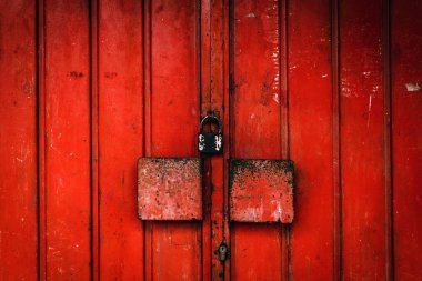 Arka plan olarak yıpranmış yüzeyi asma kilitli eski metalik garaj kapısı.