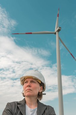 Portrait of female engineer on modern wind turbine farm during maintenance project planning clipart