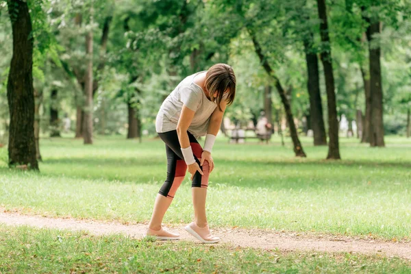 Vrouwelijke Jogger Met Pijnlijke Knieblessure Tijdens Het Joggen Het Park — Stockfoto