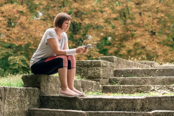 Female Jogger Texting Smartphone Running Park While Sitting Concrete Stairs — Stock Photo, Image