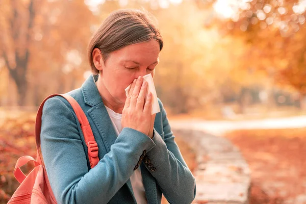 女商人在工作休息期间在秋季公园里用鼻吸纸巾 有选择地集中注意 — 图库照片