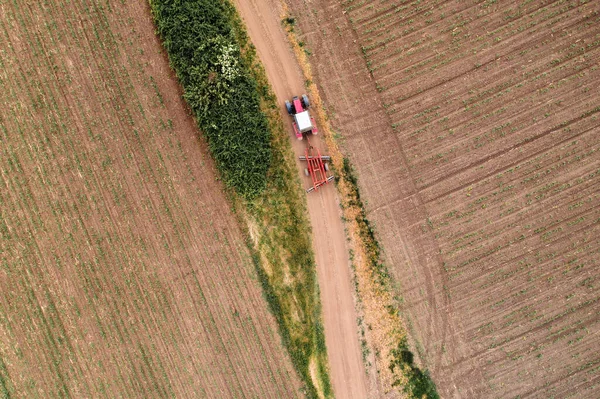 Vista Aérea Del Tractor Agrícola Camino Tierra Conduciendo Través Campos —  Fotos de Stock