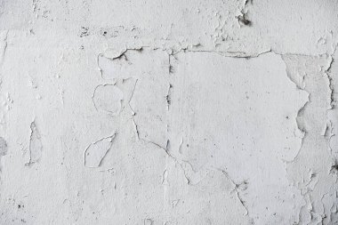 Yüzeyinde boya olan aşınmış solgun beyaz duvar dokusu arka plan olarak aşınmış ön cephe deseni.