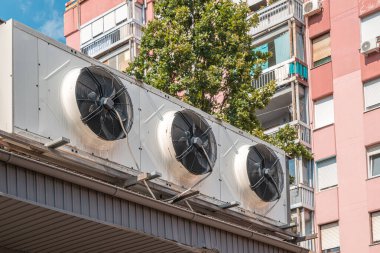 Endüstriyel vantilatörlü büyük açık hava klimaları şehirdeki bir binaya monte edildi. Seçici odak.