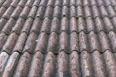 Asbest lifli beton çatı çarşaflarına kar korumaları monte edilmiş, endüstriyel yapı ayrıntıları. Seçici odak.