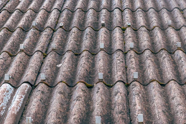 Asbest lifli beton çatı çarşaflarına kar korumaları monte edilmiş, endüstriyel yapı ayrıntıları. Seçici odak.