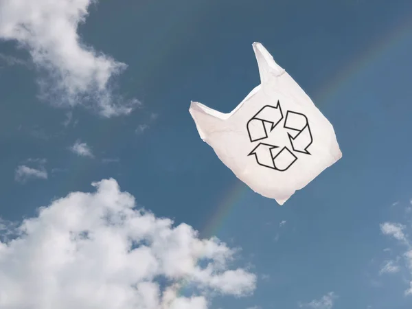 Kantong pembawa plastik putih di atas langit dan pelangi, tertiup angin . — Stok Foto
