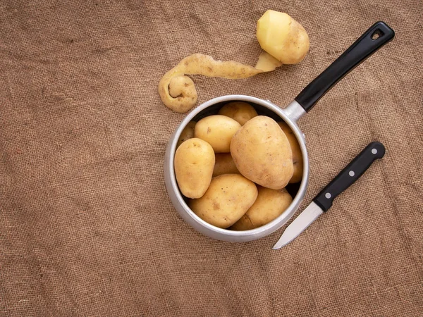 Yiyecek hazırlama, rustik ayarı natürmort tencere ile peeling patates, bıçak, kendir aka Jüt. Üstten görünüm. — Stok fotoğraf