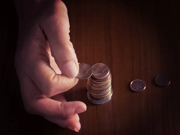 Dospělí, ženská ruka uvedení mincí do hromady, haldy, na pozadí bílý ubrus. Zavřete. Evropské mince, počítání mincí, drobné. Poznámka: filtrovaného snímku zaměřit na mince. — Stock fotografie