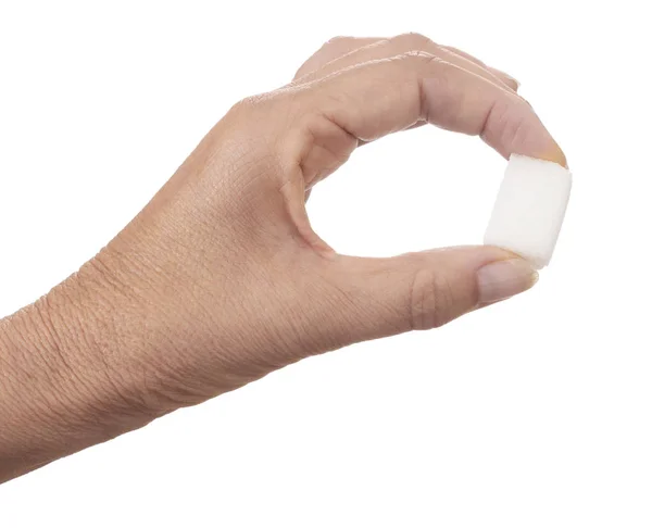 Cubo de azúcar blanco sostenido entre los dedos aislados sobre fondo blanco. Un terrón de azúcar . —  Fotos de Stock