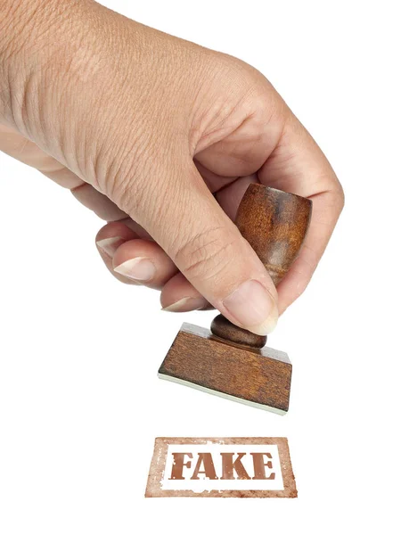 Genuine fake, rubber stamp. My hand with rubber stamp isolated on white. Business, politics or trade ethical concept. — Stock Photo, Image