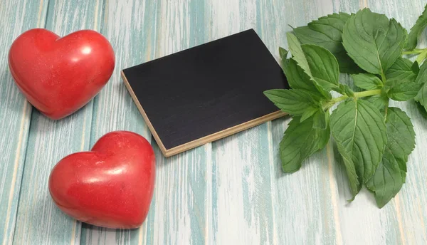 Still Life Black Chalkboard Mint Leaves Two Ceramic Red Hearts — Stock Photo, Image