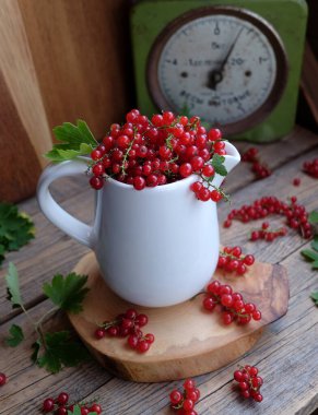 Yeşil ev ağırlıklarının arka planında kırmızı üzümlü beyaz sürahi