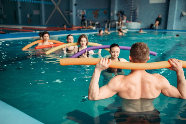 プールでのトレーニングの講師と女性グループ アクア エアロビクス トレーニング ウォーター スポーツ — ストック写真