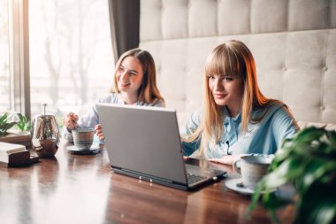 Genç kız görünüyor ürünler laptop, iş sunumu kafe, pazarlama. Modern reklam teknolojileri