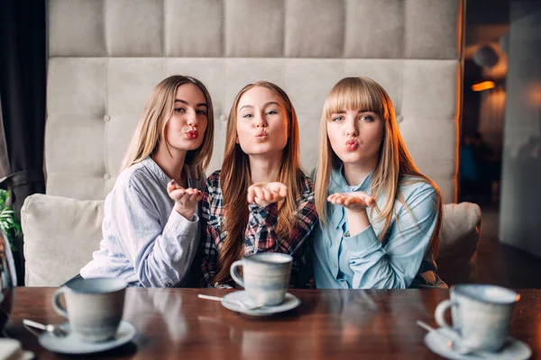 Three Happy Female Friends Drinking Coffee Cafe Showing Blown Kiss — Stock Photo, Image