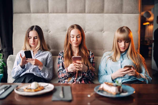 Tres Mujeres Jóvenes Sentadas Sofá Usando Teléfonos Móviles Cafetería — Foto de Stock