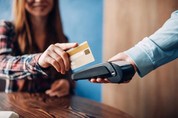 若い女性がカフェでクレジット カードで支払い端末は 現代の技術で給仕の手を払って — ストック写真
