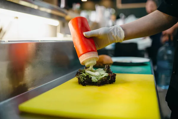 Cook Lägga Ketchup Hamburgare Beredningsprocessen — Stockfoto