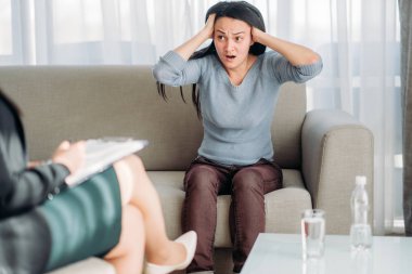 Psikoterapist, kanepede oturan Bayan hasta. Kadın doktor yazılı notlar, profesyonel psikoloji destek