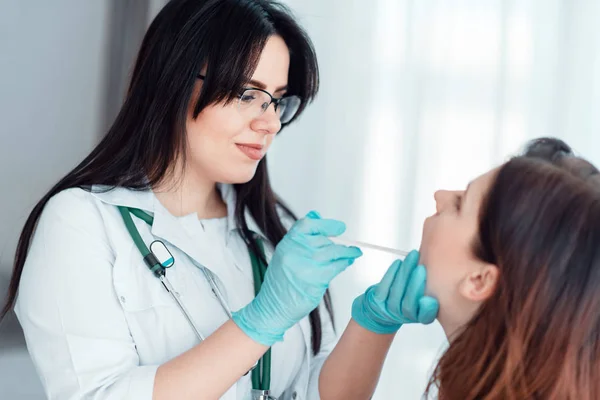 年轻妇女在家庭医生 专家检查女性患者喉部 — 图库照片