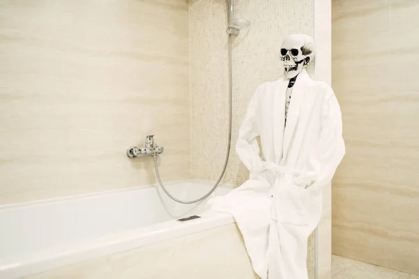 Beyaz Bornoz Banyo Banyo Kenarında Oturan Insan Iskeleti — Stok fotoğraf