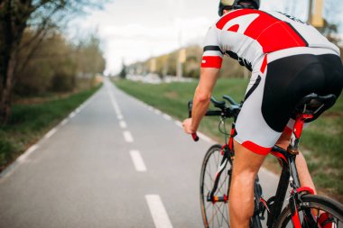 Erkek bisikletçi kask ve spor giyim binicilik bisiklet, arkadan görünüm 