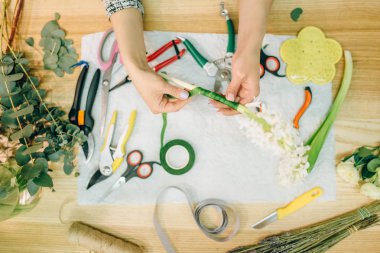 Kadın çiçekçi çiçek kompozisyon, üstten görünüm hazırlar. Çiçek iş, dekorasyon araçları