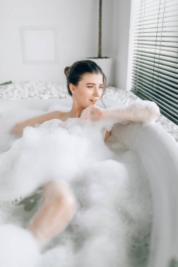 Seksi kadın yalan banyo köpüğü ile lüks banyo taş dekor ile rahatlama