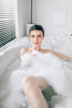 Seksi kadın yalan banyo köpüğü ile lüks banyo taş dekor ile rahatlama