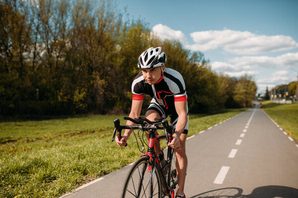 male cyclist in helmet and sportswear riding bicycle