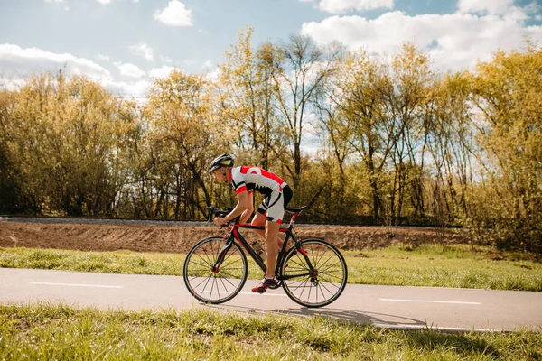 骑单车的头盔和运动服骑自行车 侧面观看 骑自行车的道路 自行车运动 — 图库照片