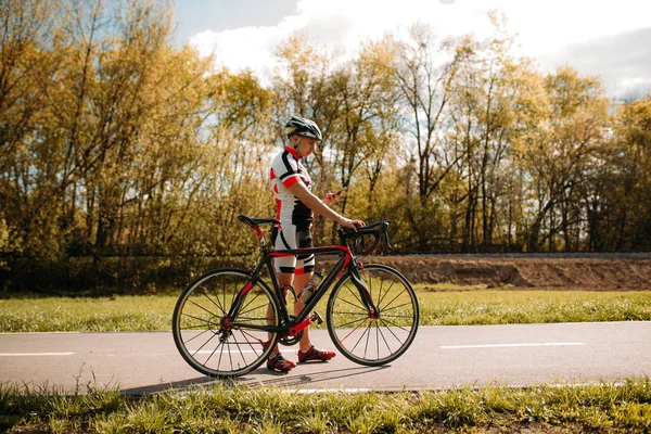 骑自行车的头盔和运动服 越野赛在沥青路的训练 男运动员骑自行车 自行车运动路径 — 图库照片
