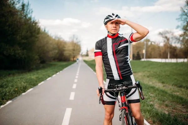 Cyclist in helmet and sportswear on sport bicycle. Training on bike path, cycling